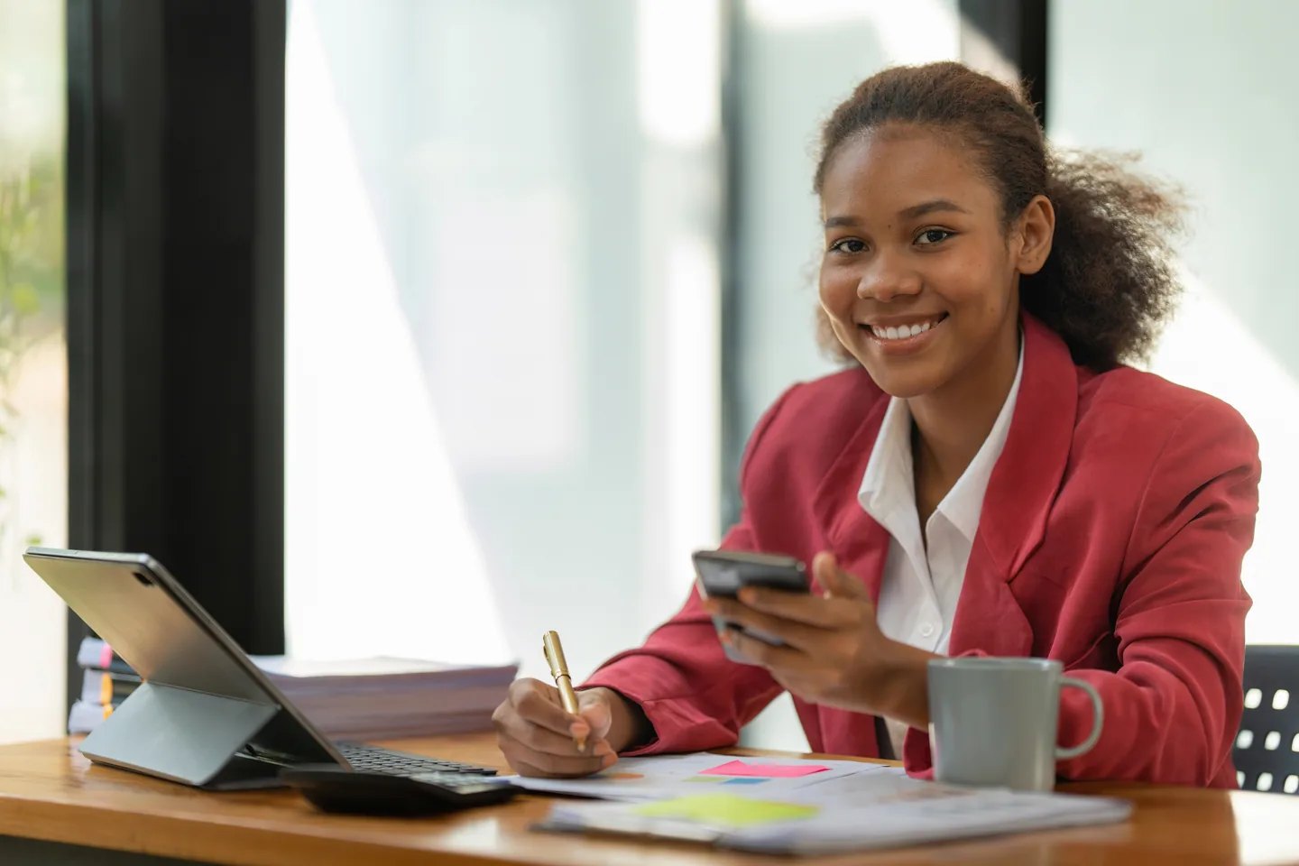 Businesswoman reviewing financial paperwork at a desk.